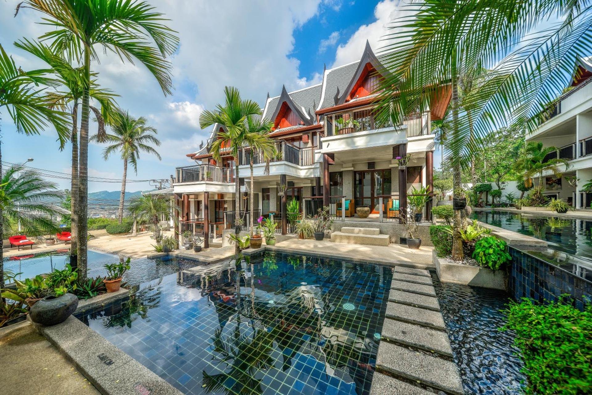 Four-tier pool framed by palms and Thai-gable villas