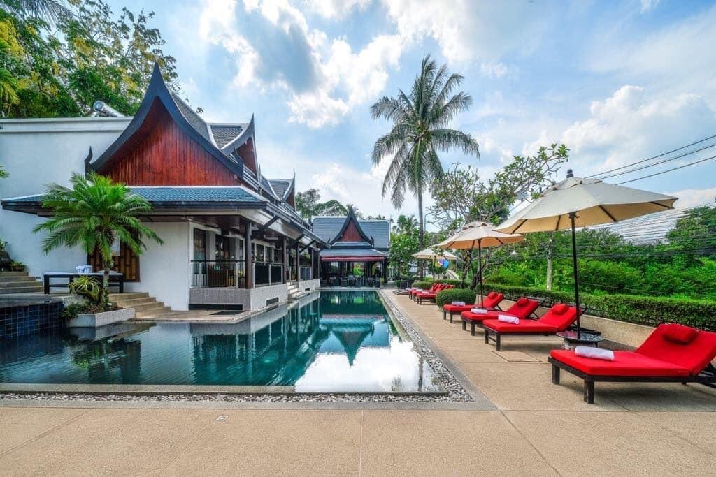 Red pool loungers under the Thai-gable villa