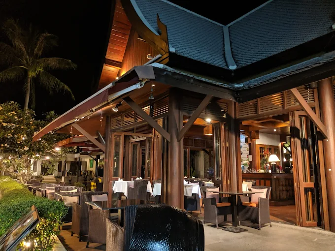 RICE restaurant exterior at night — teak pavilion under the Thai roof