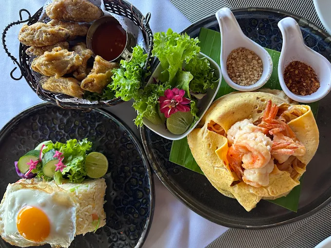 Thai lunch spread — pad thai, fried chicken, egg on rice